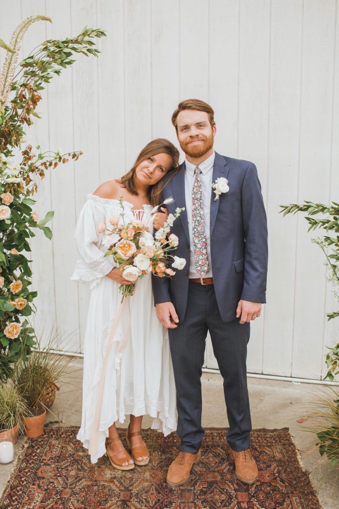 couple standing in boho floral installation